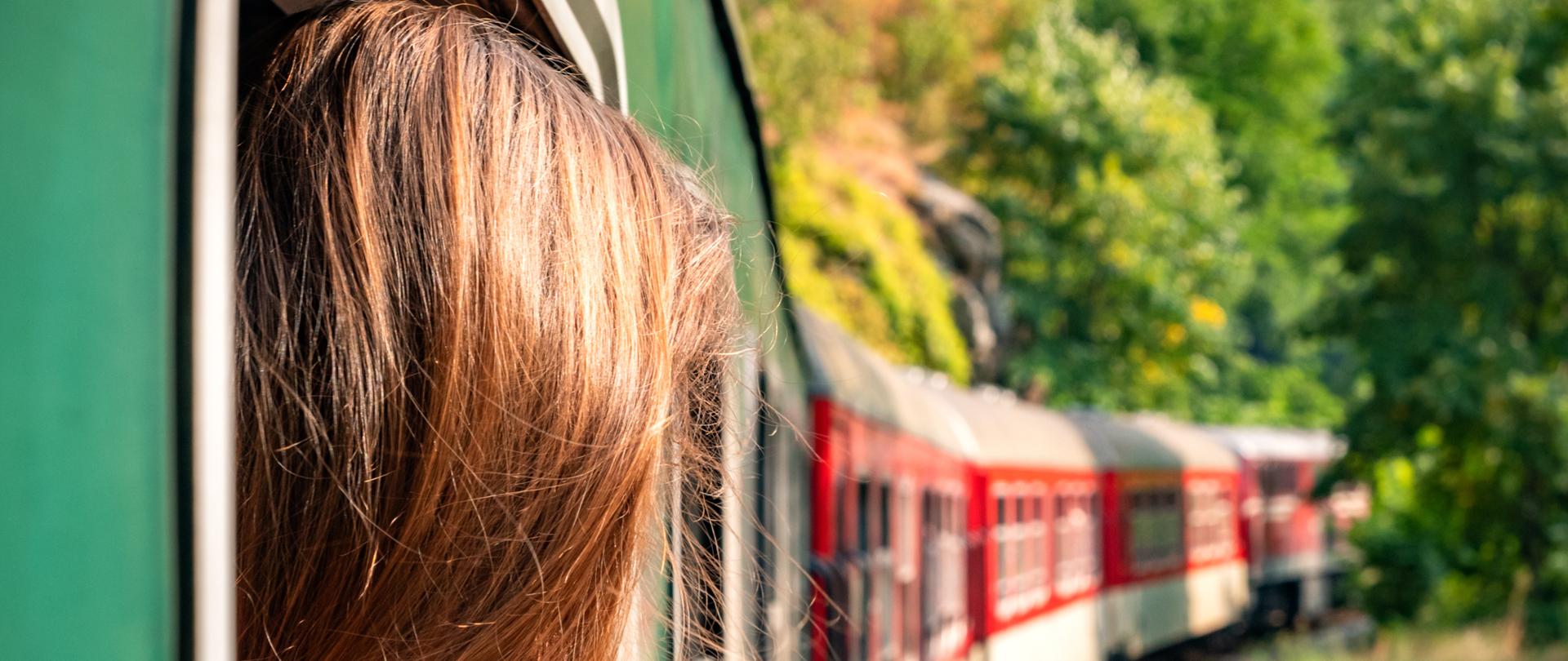 Woman looking out the window of the old train. Bulgarian mountains, Alpine railway in the Balkans