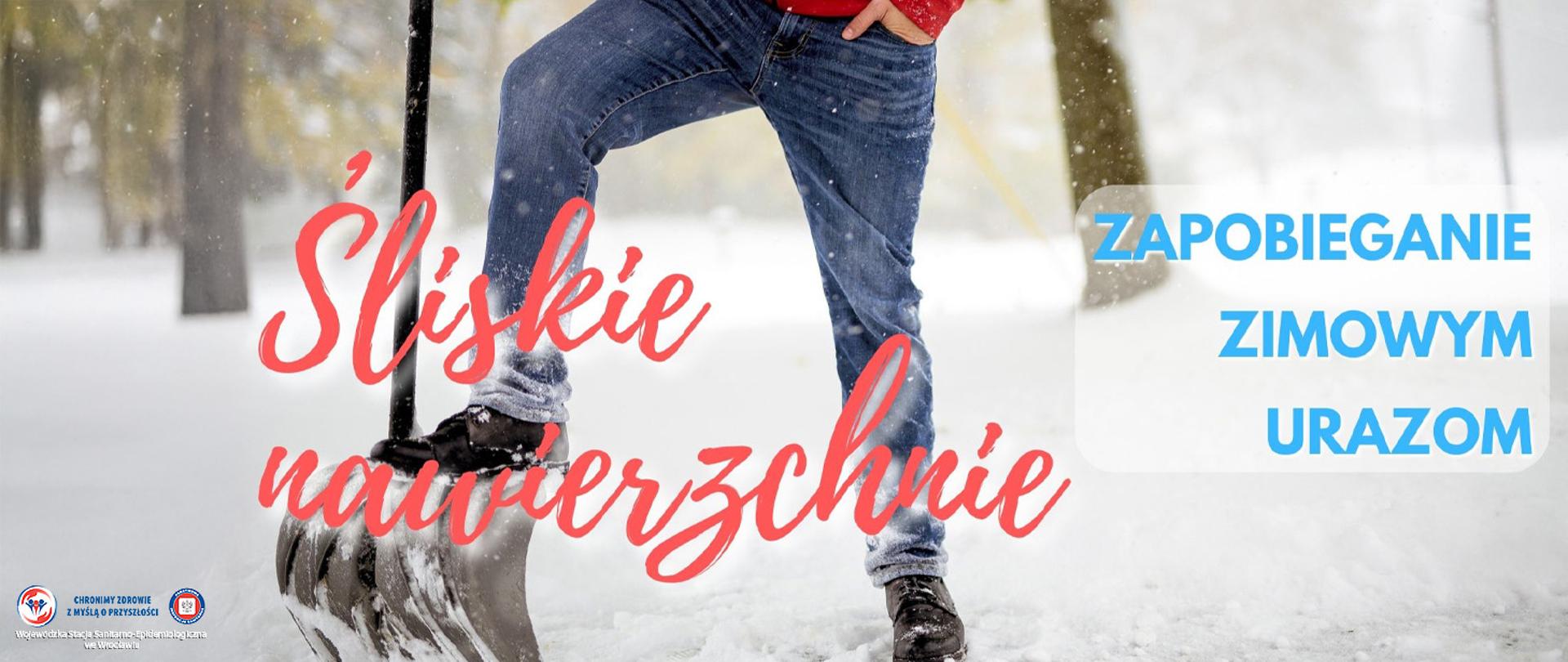 Osoba odśnieżająca zimowy chodnik stoi z szuflą koło zaspy