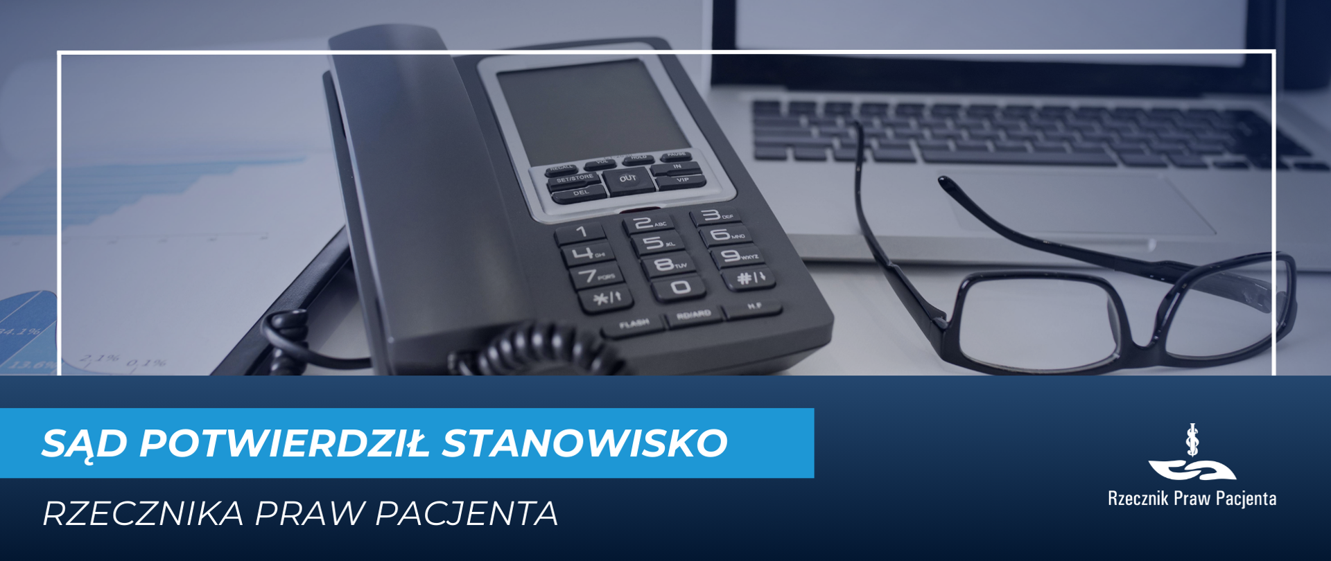 Na biurku jest telefon ze słuchawką oraz komputer. 