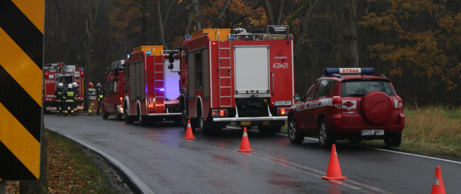 Zdjęcie przedstawia samochody strażackie stojące na drodze.