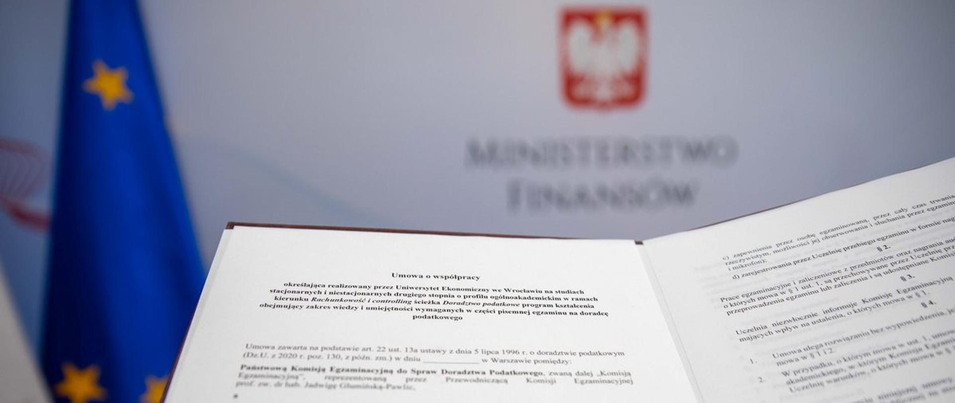 Tekst umowy o współpracy na tle banera Ministerstwa Finansów 