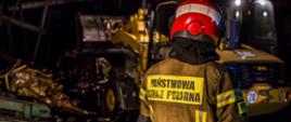 Zdjęcia wykonane w porze nocnej. Przedstawiają działania strażaków PSP i OSP w trakcie działań ratowniczo-gaśniczych przy pożarze hali produkcyjnej na terenie tartaku w miejscowości Grodzisko, powiat strzelecki.