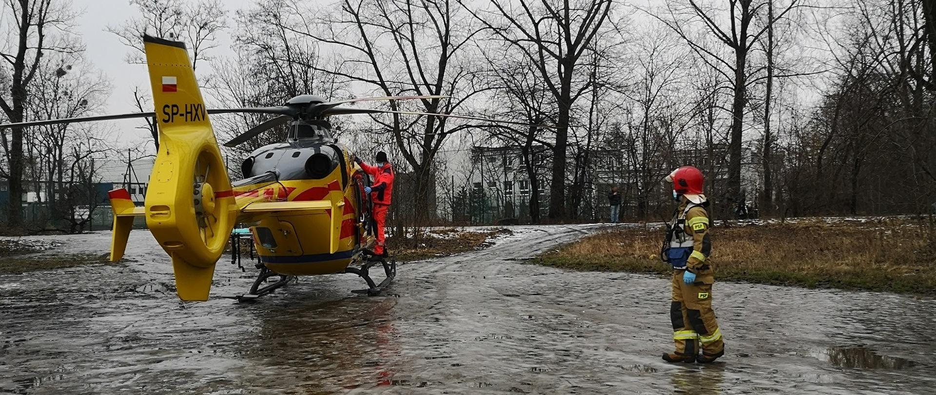 Zdjęcie przedstawia kierującego działaniem ratowniczym zmierzającego do śmigłowca.