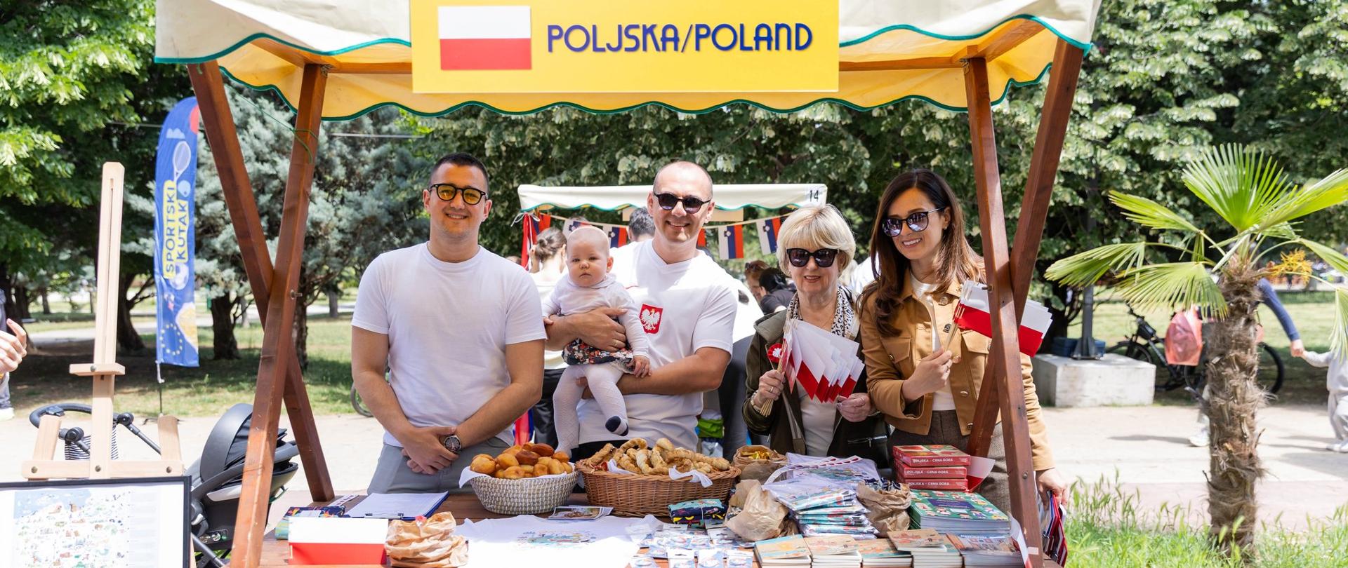 Stoisko Ambasady RP w Podgoricy podczas EU fair z okazji Dnia Europy; napis EU FAIR 2026; przedstawiciele Ambasady i Stowarzyszenia przy stoisku z flagami Polski