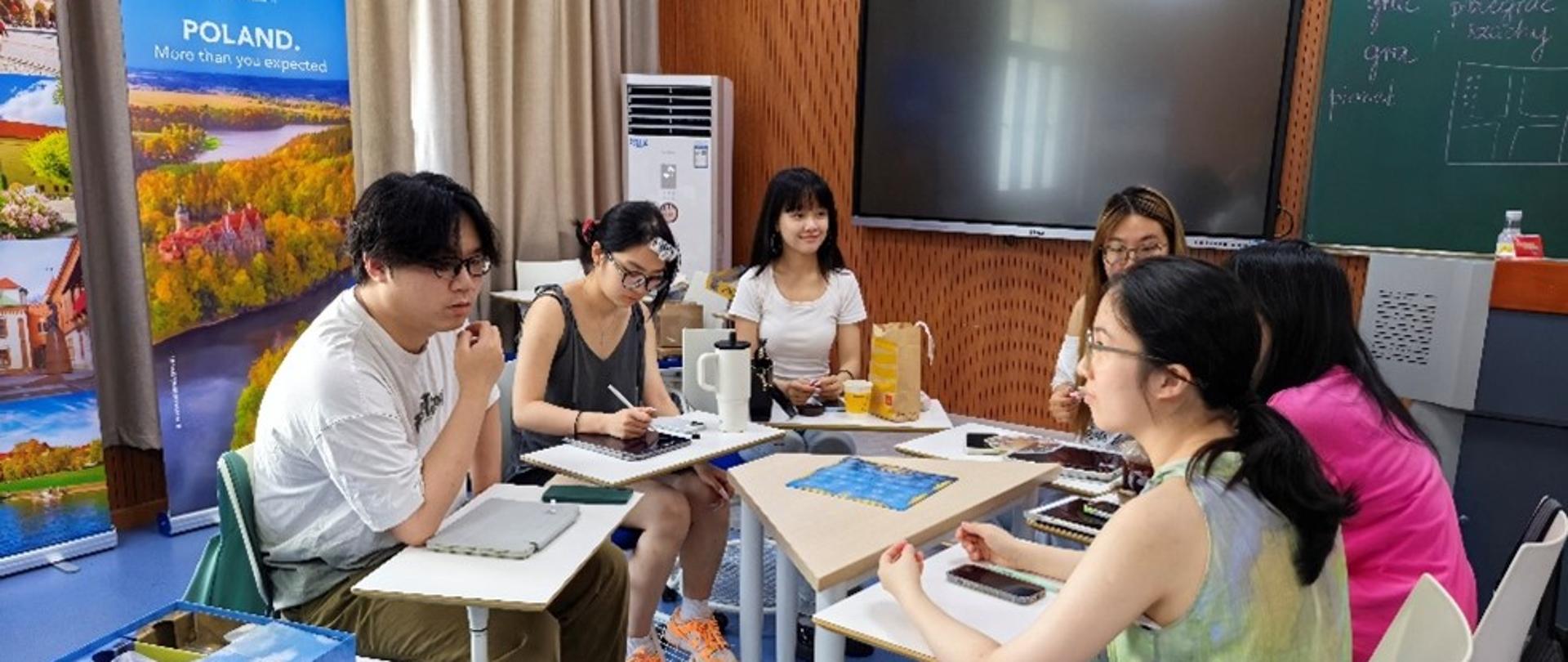 grupa młodych ludzi przy stole