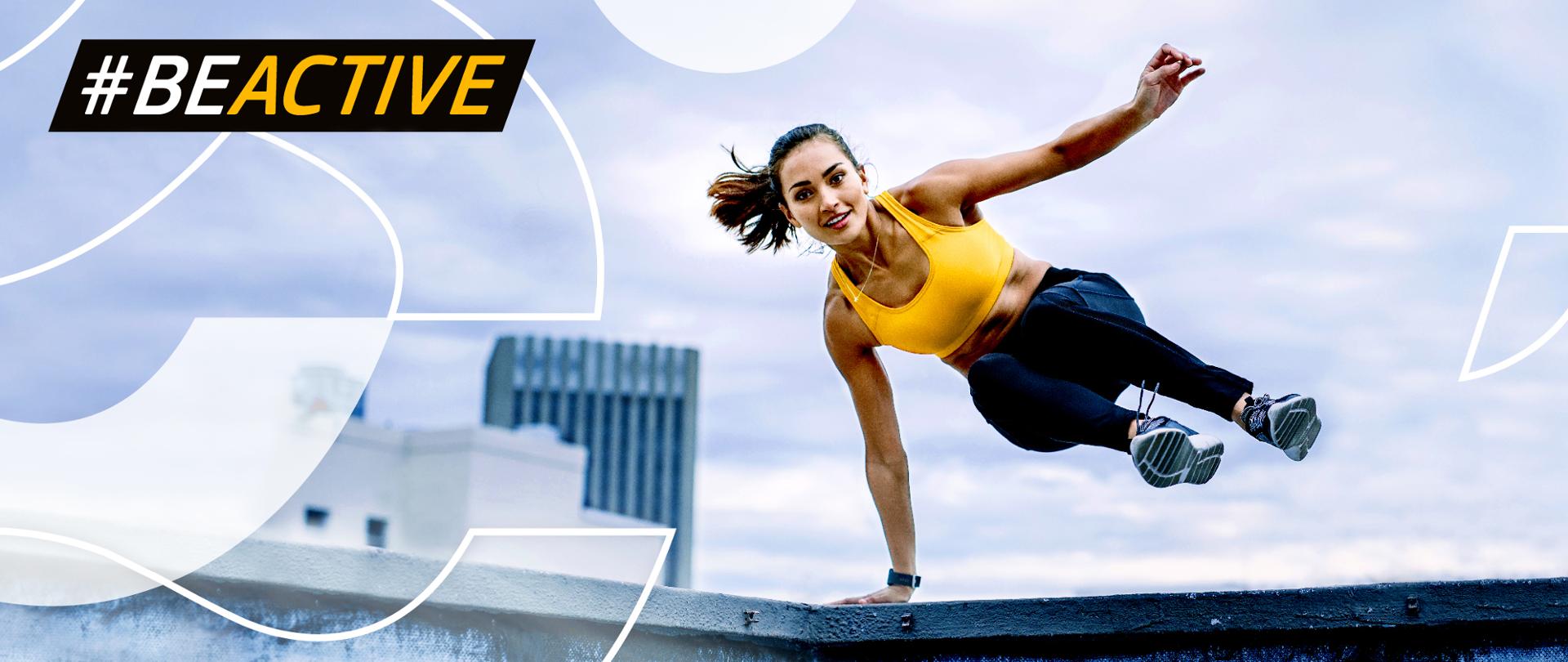 Grafika ze skaczącą kobietą w żółtym topie i napis Be Active