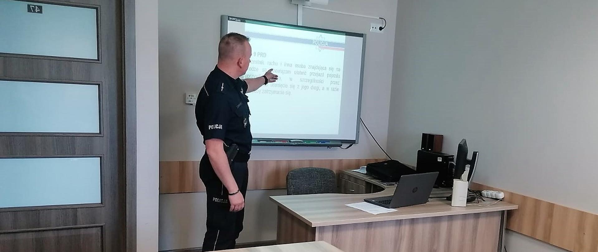 Warsztaty dotyczące przepisów ruchu drogowego. Prowadzący mł.asp. Krzysztof Świerczyński podczas omawiania zagadnienia.