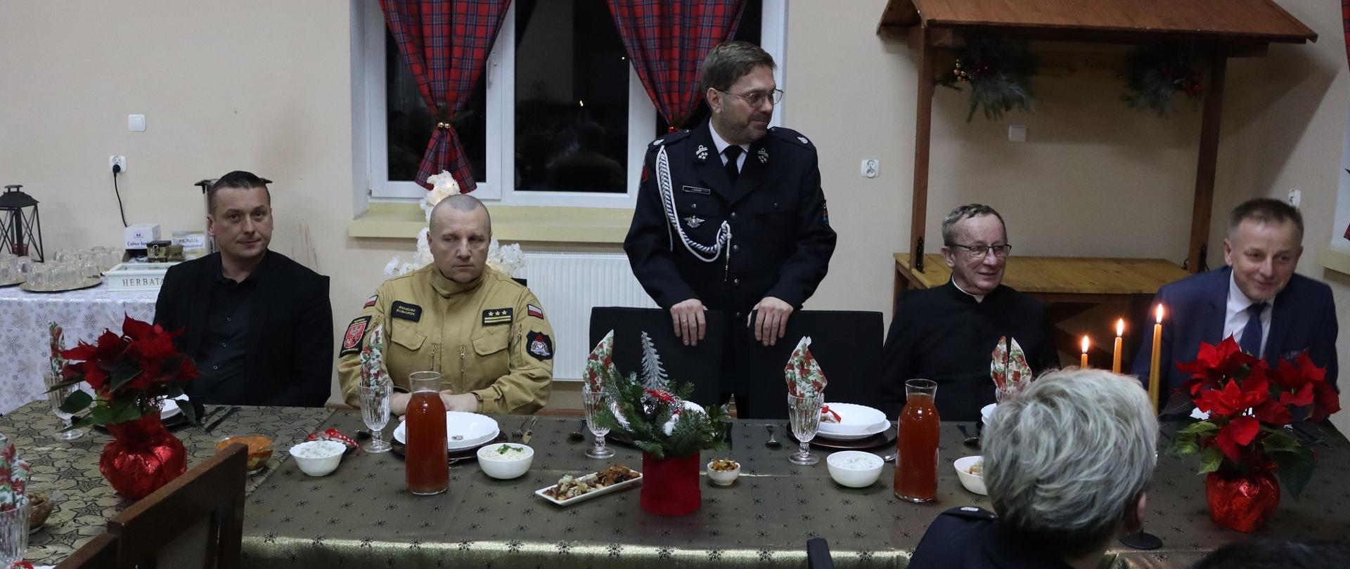 Strażackie Spotkanie Opłatkowe w OSP Żelaznej Górze, za świątecznym stołem siedzą zaproszeni goście.
