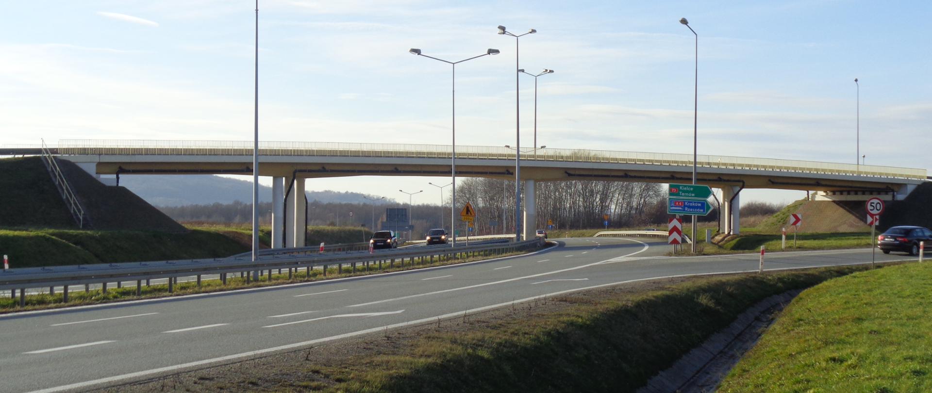 droga dwupasmowa dwujezdniowa, nad drogą wiadukt, zjazd z drogi w prawo