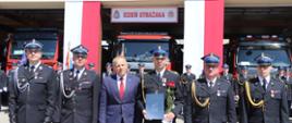 Odznaczony Srebrnym Medalem za Zasługi dla Pożarnictwa na pamiątkowym zdjęciu
