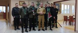 Zdjęcie przedstawia harcerzy, którzy przekazali Betlejemskie Światło Pokoju, Zastępcę KP PSP w Pruszczu Gdańskim, oraz strażaków z JRG w Pruszczu Gdańskim