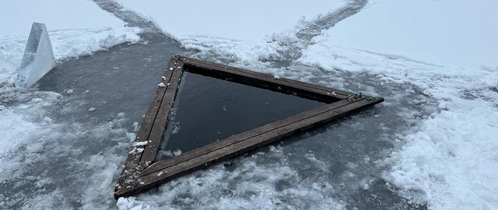 Trójkątny przerębel zabezpieczony specjalnymi deskami.