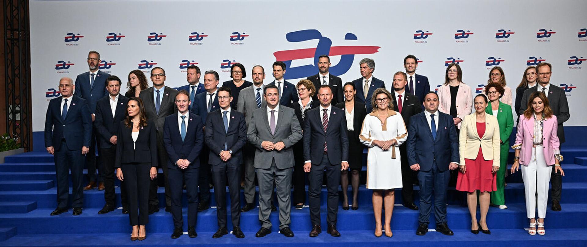 Rada nieformalna - COMPET Turystyka w Warszawie. Family foto na ściance z logo prezydencji