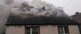 Dom mieszkalny. Dym wydobywa się z dachu budynku