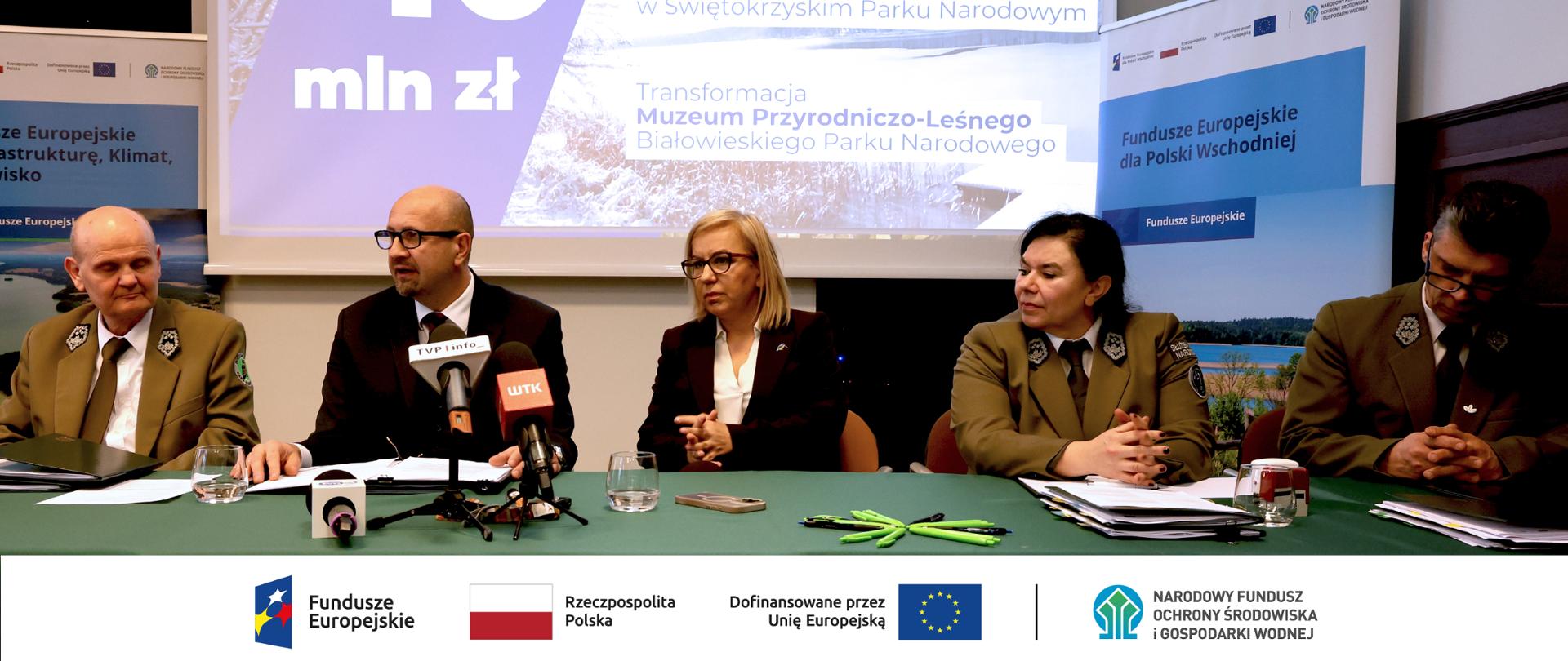 Zdjęcie ilustracyjne. Na zdjęciu za stołem prezydialnym siedzą dwie kobiety i trzech panów. od lewej: Zbigniew Sołtysiński, dyrektor Wielkopolskiego Parku Narodowego, Robert Gajda, zastępca prezesa zarządu NFOŚiGW, Paulina Hennig-Kloska, ministra klimatu
i środowiska, Olimpia Pabian, dyrektor Białowieskiego Parku Narodowego, Jan Reklewski, dyrektor Świętokrzyskiego Parku Narodowego. W stopce grafiki ciąg logotypów: Fundusze Europejskie, flaga Rzeczypospolita Polska, flaga UE i Dofinansowane przez UE, NFOŚiGW.