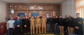 Grupowe zdjęcie w sali pamięci KM PSP Gdynia