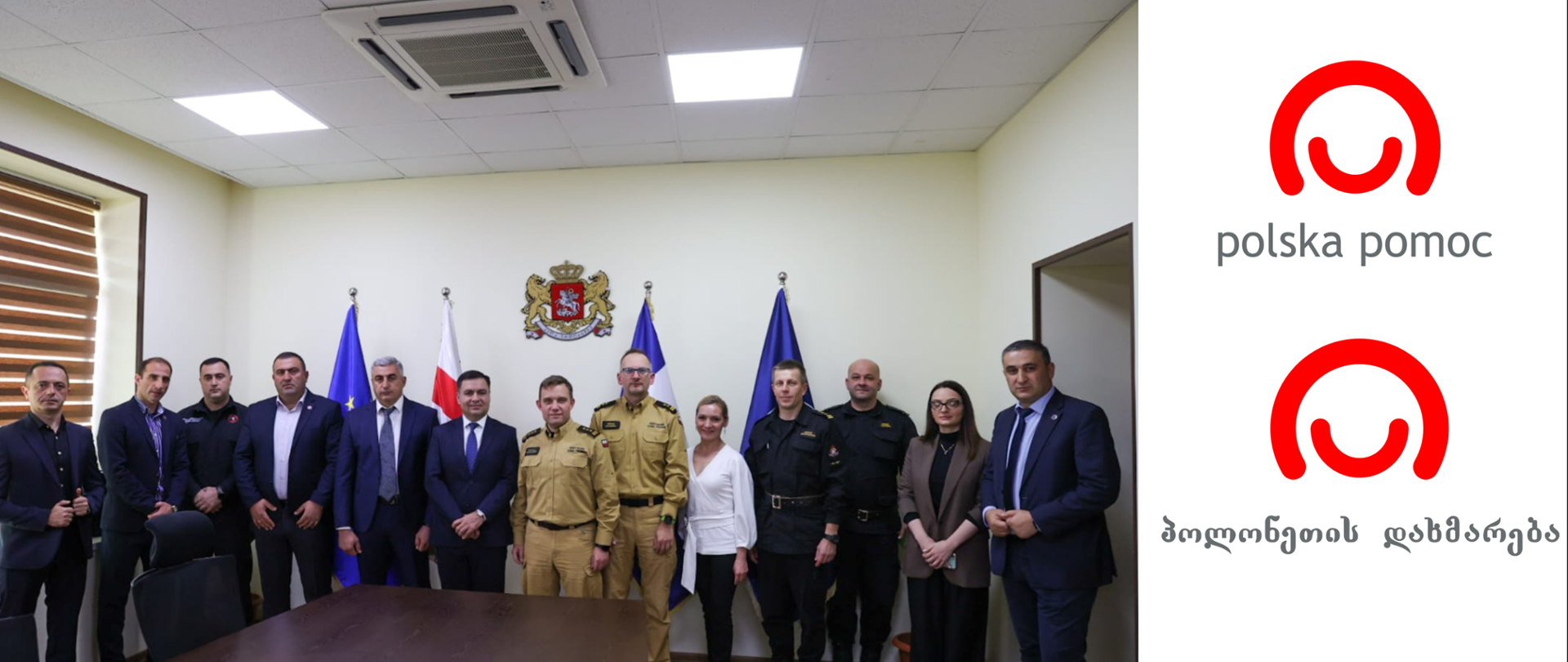 Grupowe zdjęcie przedstawicieli PSP i strony gruzińskiej, po prawo logotypy polskiej pomocy z napisem w języku polskim i gruzińskim