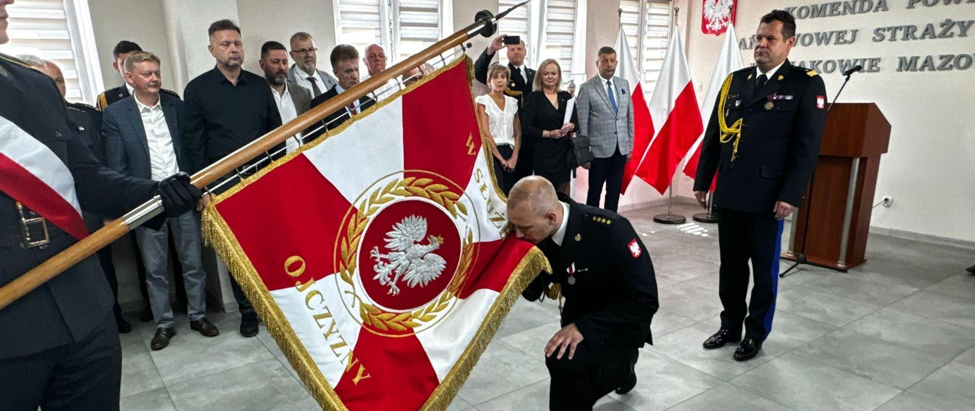 Powołany Komendant Powiatowy PSP wita się ze sztandarem podczas uroczystości