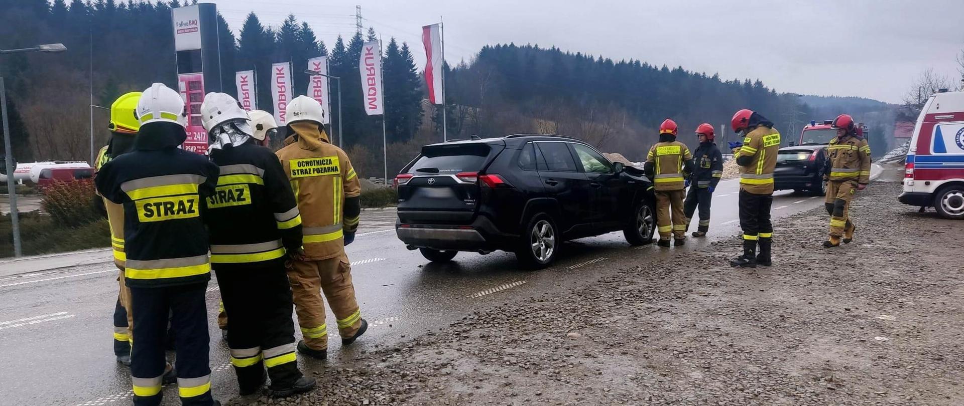 Samochody uczestniczące w zdarzeniu a obok strażacy