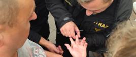Strażak zdejmuje przeciętą obrączką