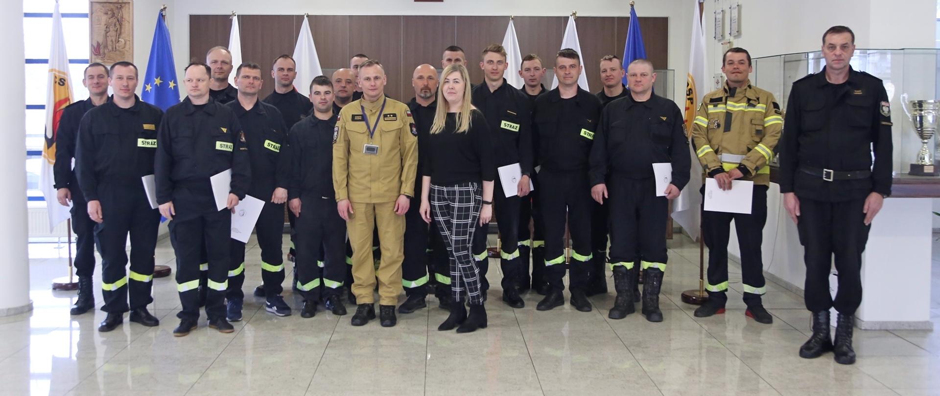 Grupowe zdjęcie uczestników szkolenia w towarzystwie Zastępcy Komendanta Centralnej Szkoły PSP, pracownicy wydziału szkoleń specjalistycznych i współpracy międzynarodowej oraz naczelników wydziału technicznego i wydziału szkoleń specjalistycznych i współpracy międzynarodowej