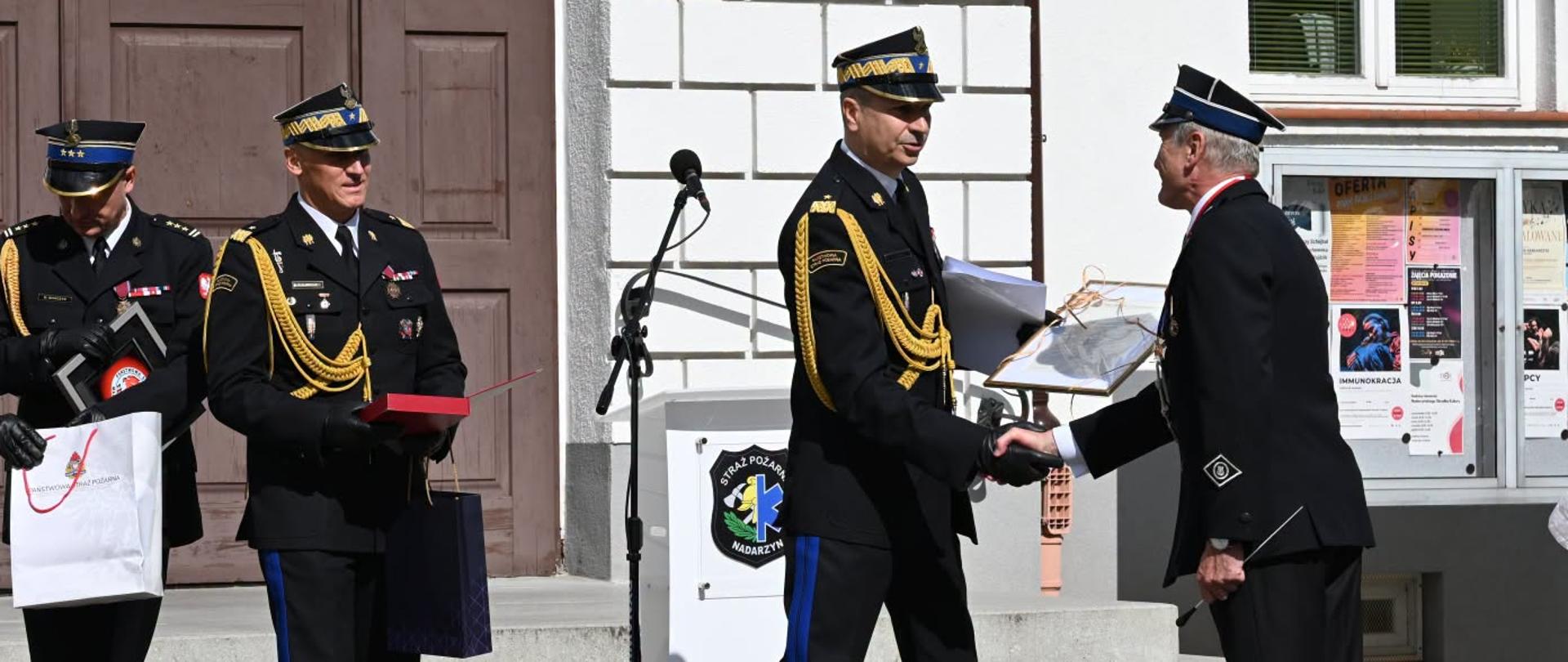 Dwóch funkcjonariuszy podaje sobie rękę.