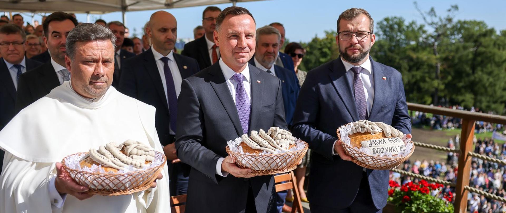 Prezydent Andrzej Duda i minister rolnictwa i rozwoju wsi Grzegorz Puda trzymający przed sobą w rękach koszyki z bochnami chleba