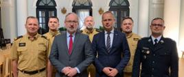 Pozujący do zdjęcia: minister zdrowia Adam Niedzielski, poseł na sejm Paweł Hreniak, zastępca komendanta głównego PSP, nadbryg. dr inż. Adam Konieczny oraz trzech oficerów PSP i druh OSP w osobach: st. bryg. Robert Piec, bryg. Szymon Kokot oraz st. kpt. Tomasz Milczarczyk, druh Sylwester Witczak, członek Zarządu Głównego ZOSP RP.