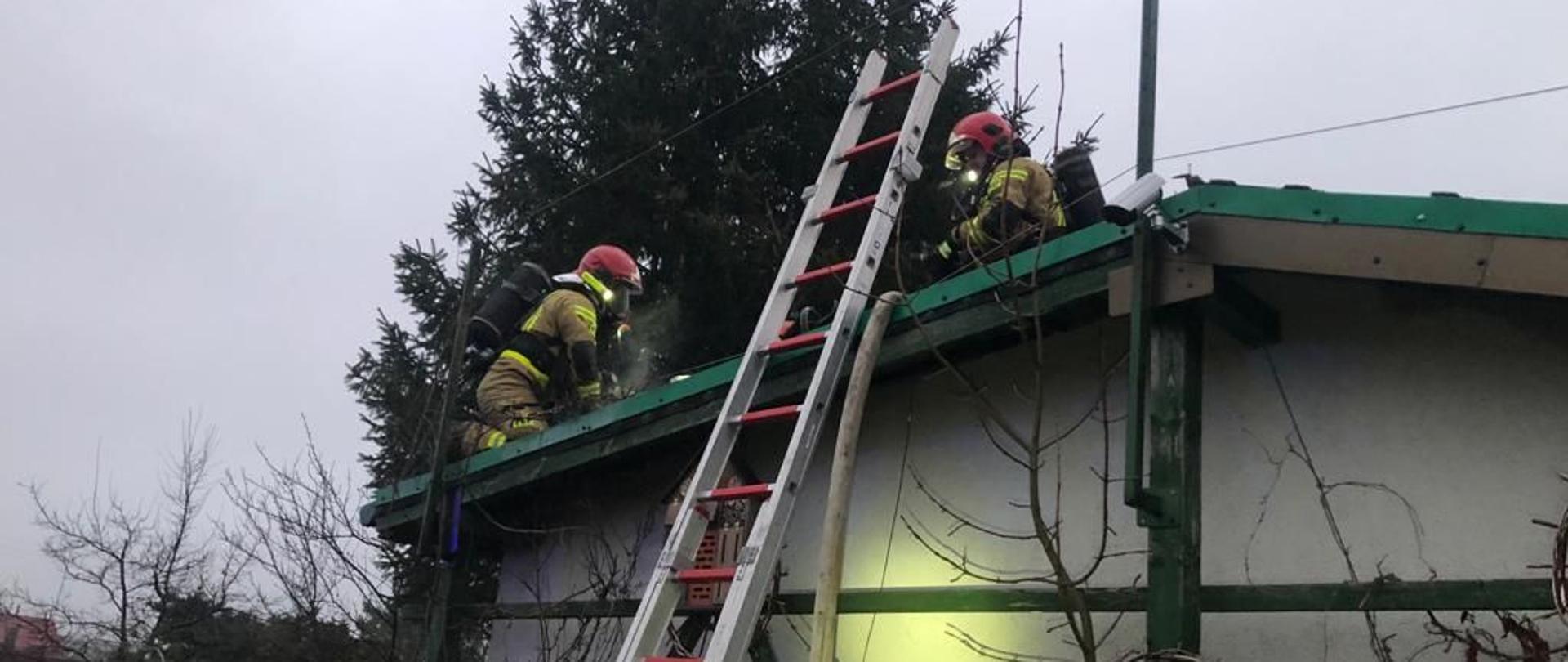 Altana zewnątrz, dwóch strażaków na dachu.