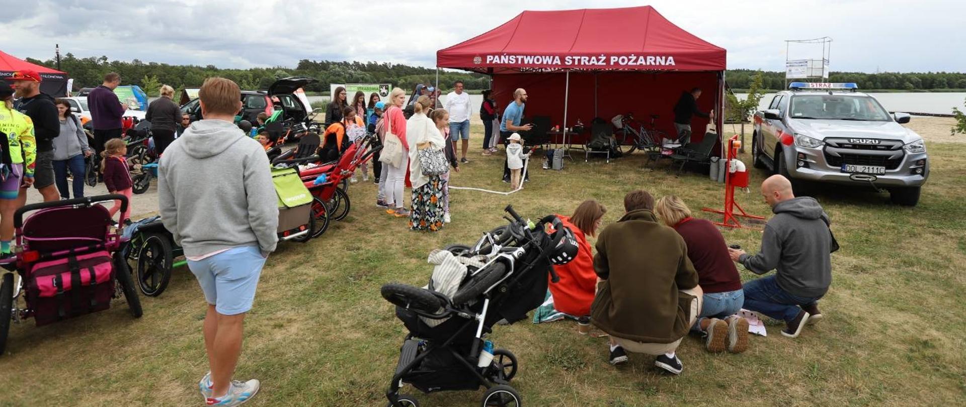 Na zdjęciu widoczny namiot PSP oraz samochód rozpoznawczo ratowniczy oraz ludzie korzystający z atrakcji przygotowanych przez PSP. 