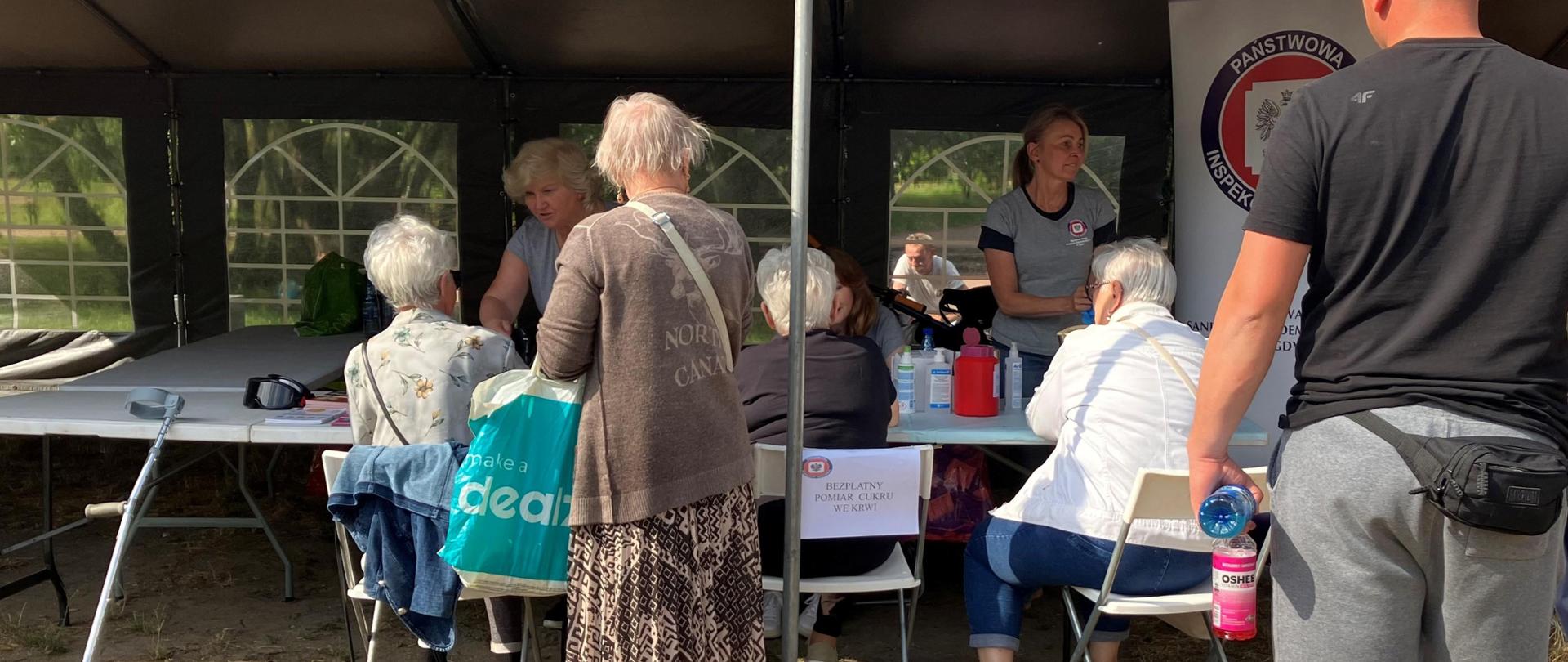 Ludzie przy stanowisku PSSE w Gdyni w trakcie Festynu Rodzinny Park Kioloński w dniu 08.06.2024