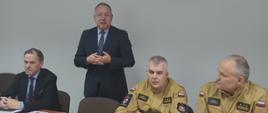 Podczas narady przemawia Wiceprezydent Ostrowca Św. Obok znajduje się Zastępca Świętokrzyskiego Komendanta Wojewódzkiego, Wicestarosta i Komendant Powiatowy PSP w Ostrowcu Św.