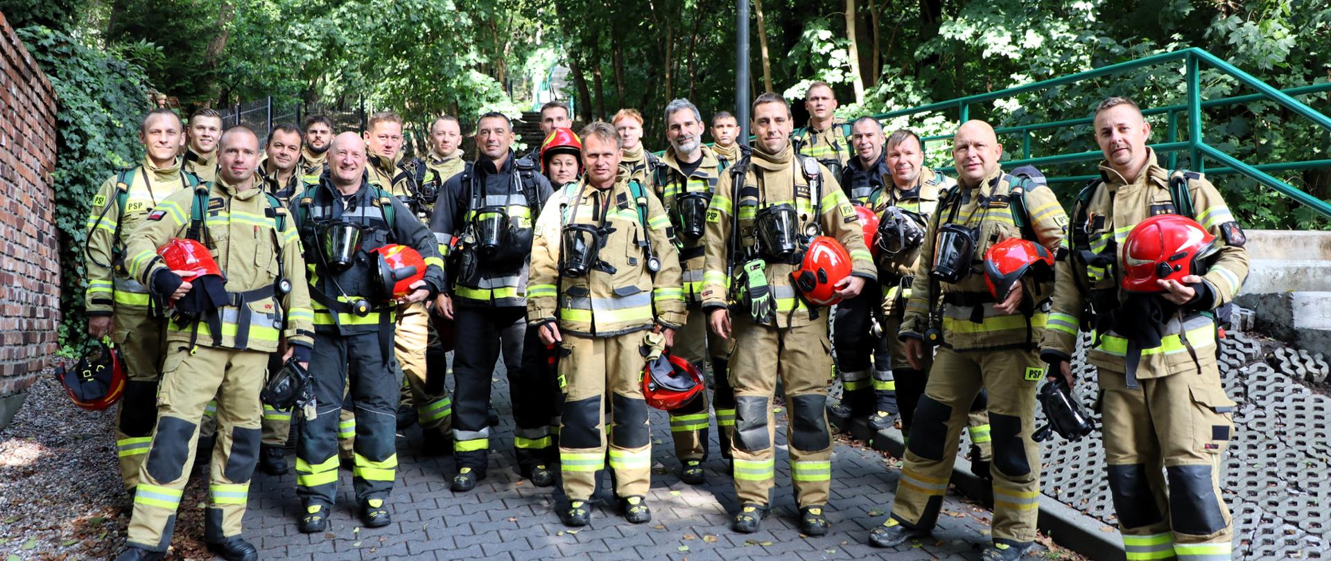 strażacy PSP w pełnym umundurowaniu bojowym przed rozpoczęciem honorowej wspinaczki