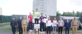 Dekoracja 6 najlepszych zawodników. Zawodnicy stoją na podium z pucharami i dyplomami