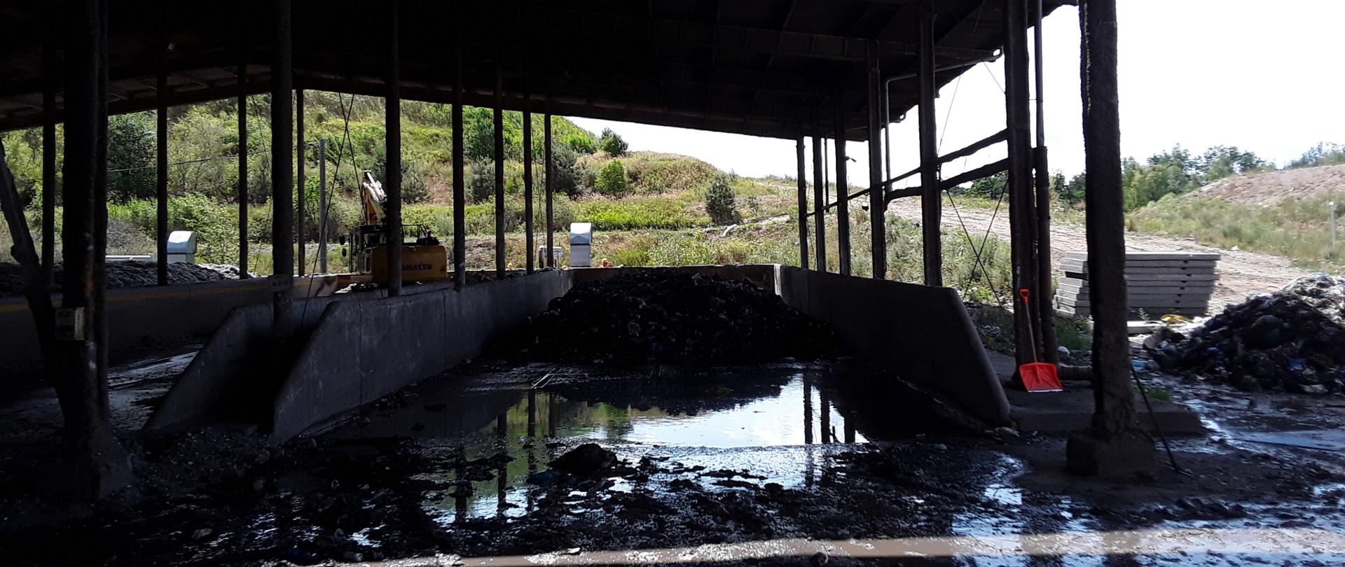 Zadaszony, otwarty boks zalany wodą pochodząca z gaszenia pożaru.