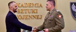 Porozumienie Rządowego Centrum Bezpieczeństwa i Akademii Sztuki Wojennej w sprawie organizacji szkolenia z zakresu zarządzania bezpieczeństwem narodowym. Zdjęcie przedstawia sygnatariuszy porozumienia. W tle "Akademia Sztuki Wojennej".
