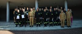 Grupowe zdjęcie funkcjonariuszy PSP będących uczestnikami (23 osoby) szkolenia w towarzystwie Zastępcy Komendanta Centralnej Szkoły PSP, czterech funkcjonariuszy CS PSP oraz kobiety