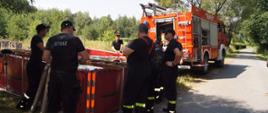 Na zdjęciu strażacy napełniają zbiornik przenośny 