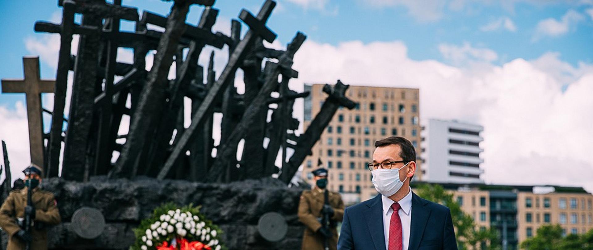 Premier idzie, w tle pomnik Poległym i Pomordowanym na Wschodzie.