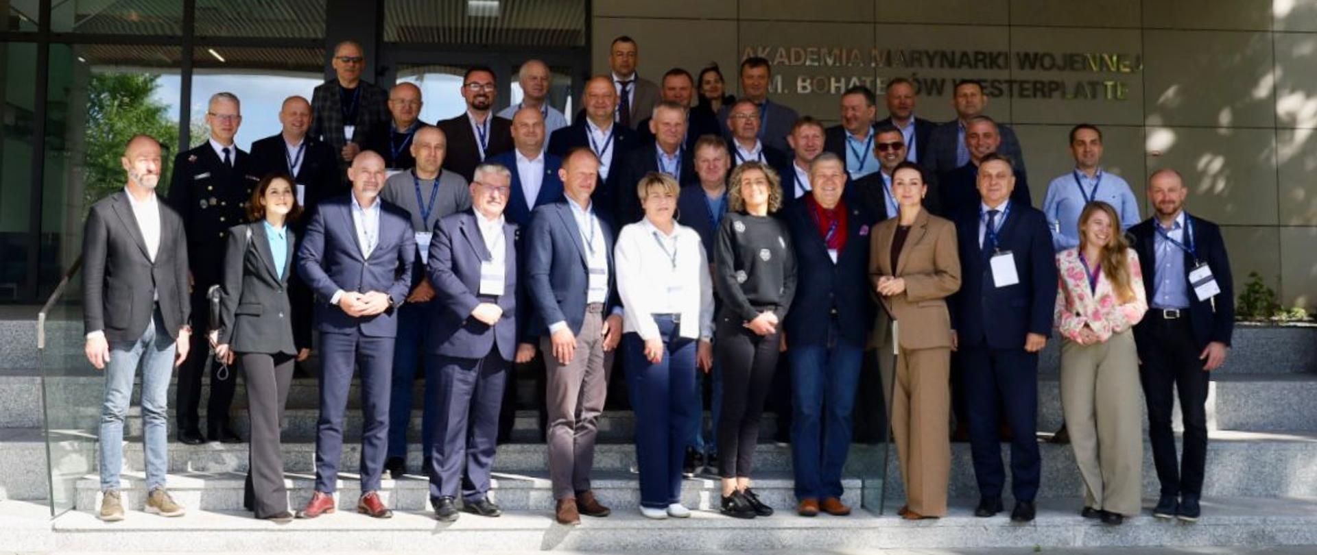 grupa osób stoi na schodach i pozuje do zdjęcia