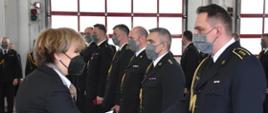 Hanna Zdanowska składa gratulacje strażakowi z okazji awansu