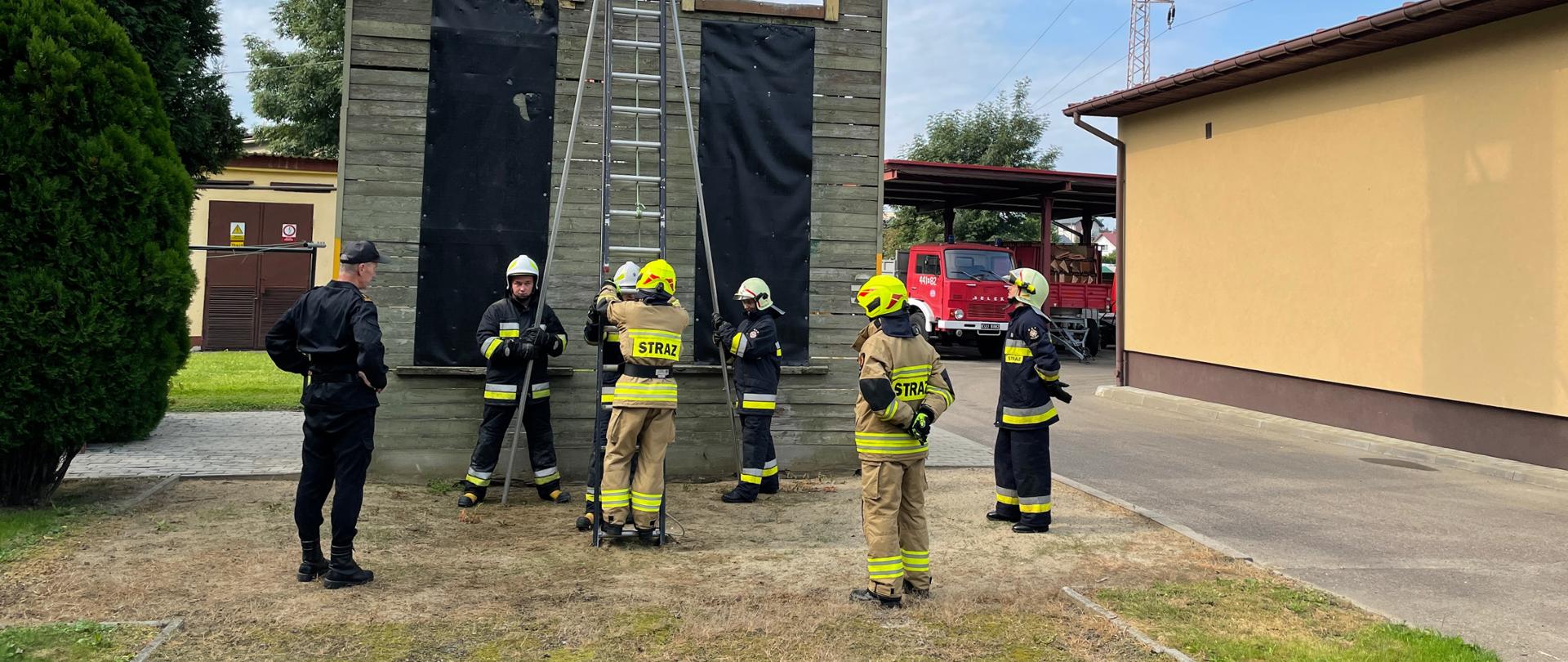 Na zdjęciu druhowie z Ochotniczej straży pożarnej wykonują asekurowane wejście po drabinie, obok brygadier Sławomir Madejczyk z Komendy Powiatowej Państwowej Straży Pożarnej w Jaśle
