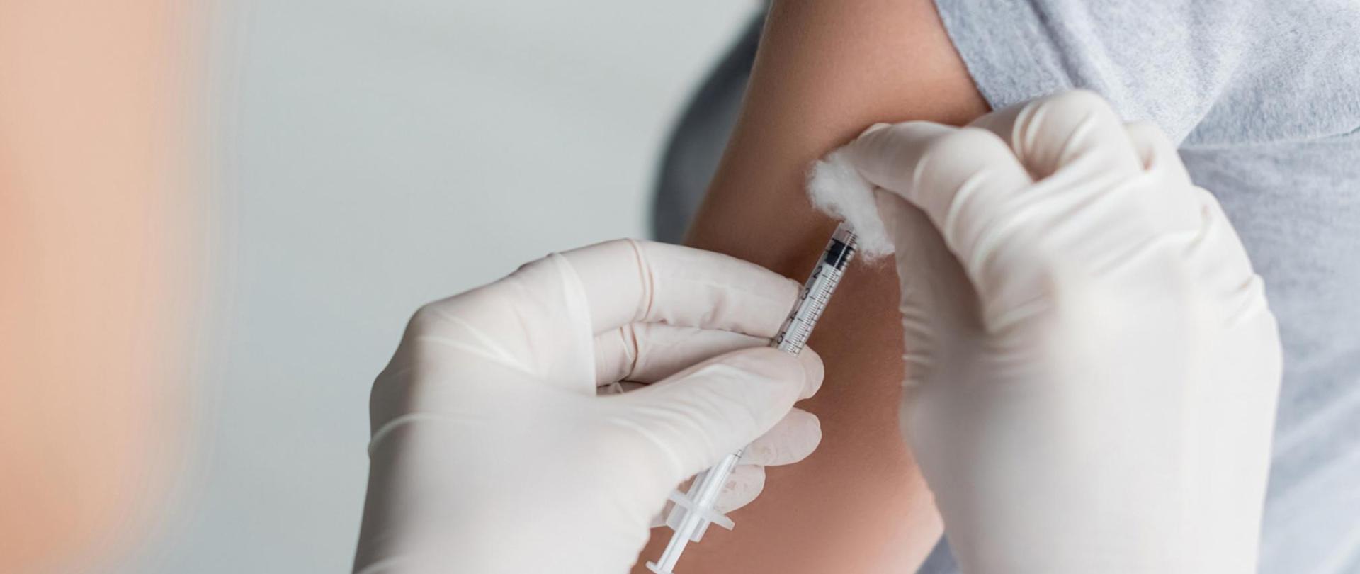 Na zdjęciu jest pacjent szczepiony przez medyka.