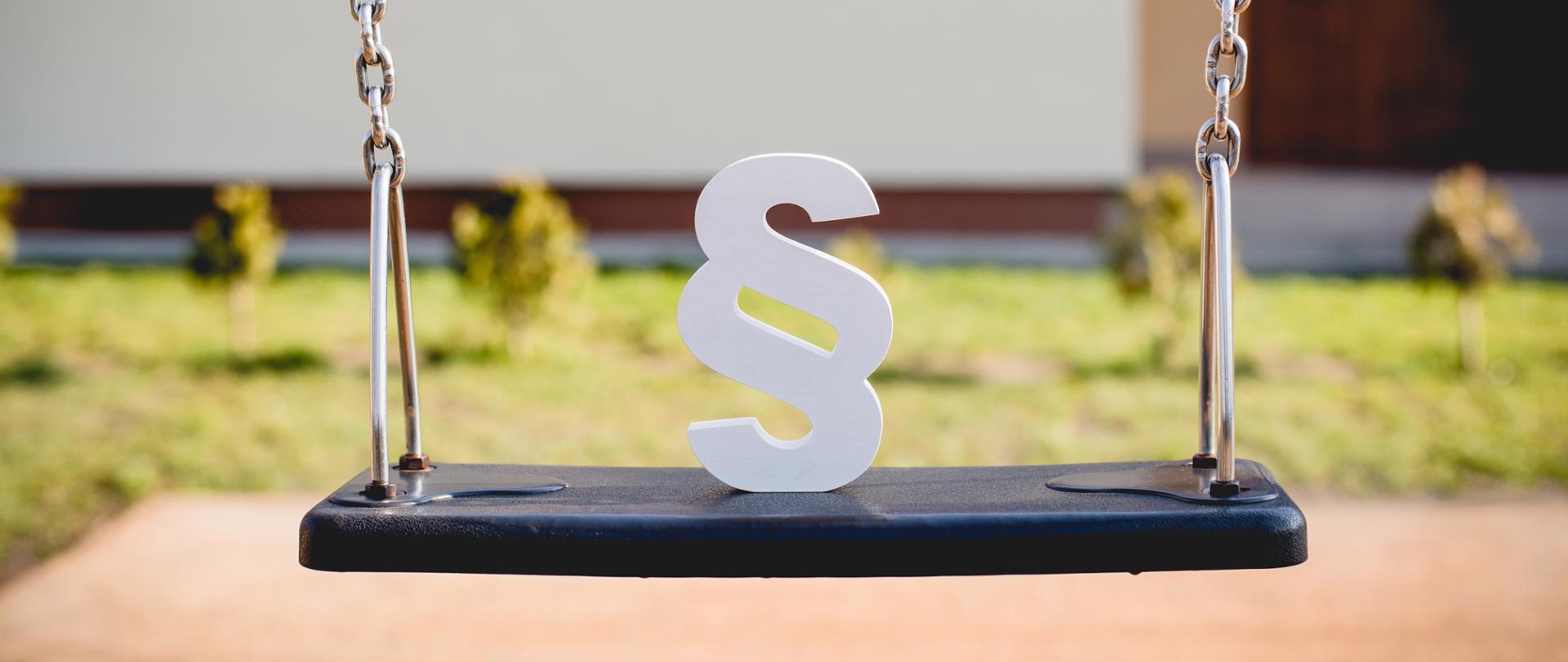 Biały paragraf na huśtawce łańcuchowej