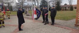 mł. bryg. Arkadiusz Lichota salutuje żegnając się z pochylonym przez poczet sztandarowy sztandarem komendy.