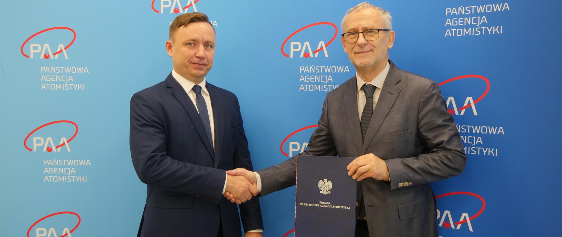 Prezes Państwowej Agencji Atomistyki Andrzej Głowacki (po lewej) wręczył decyzję o autoryzacji dyrektorowi Narodowemu Centrum Badań Jądrowych prof. dr. hab. inż. Krzysztofowi Kurkowi (po prawej)