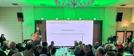 Uczestnicy wydarzenia siedzący na sali konferencyjnej wraz z mówcą.