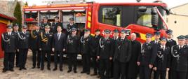 Na zdjęciu widać strażaków i zaproszonych gości. Za nim stoi nowy samochód gaśniczy. 