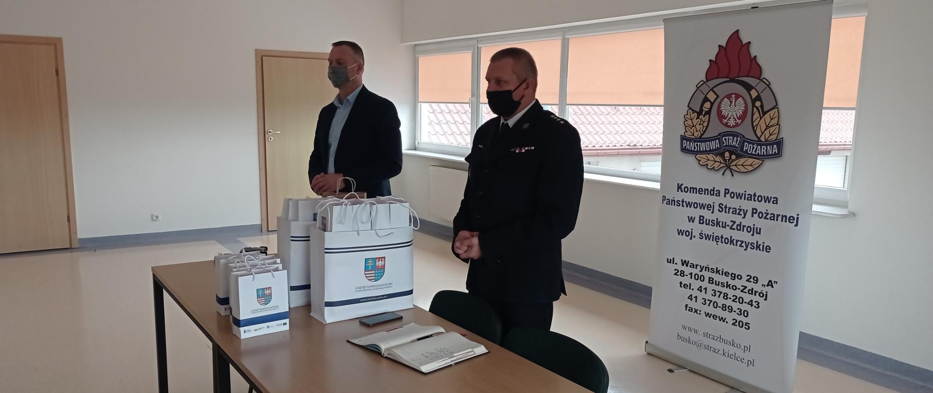 Na zdjęciu zastępca komendanta powiatowego PSP oraz przedstawiciel Marszałka Województwa Świętokrzyskiego omawiający zasady przekazywania pulsoksymetrów