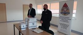 Na zdjęciu zastępca komendanta powiatowego PSP oraz przedstawiciel Marszałka Województwa Świętokrzyskiego omawiający zasady przekazywania pulsoksymetrów